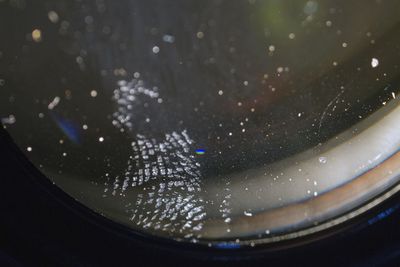 Close-up of camera seen through glass