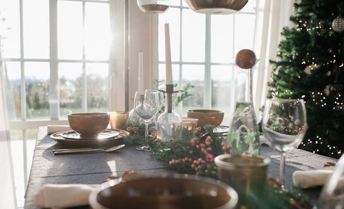 Tall candles on a decorated dinner table at home at christmas