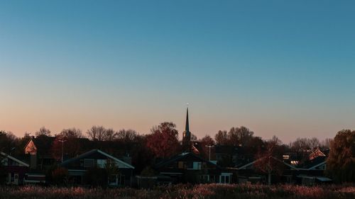 Houses against clear sky at sunset