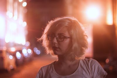 Close-up of woman looking away on street in city at night