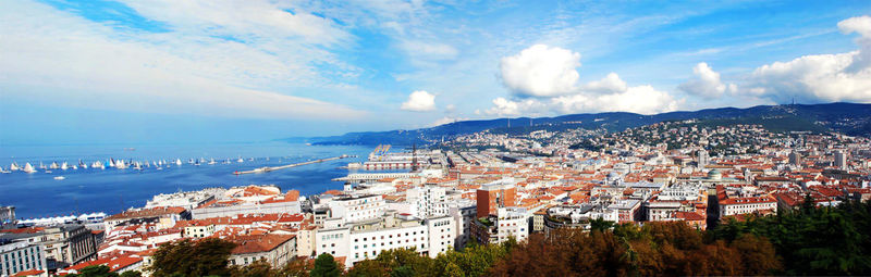 High angle view of townscape by sea against sky