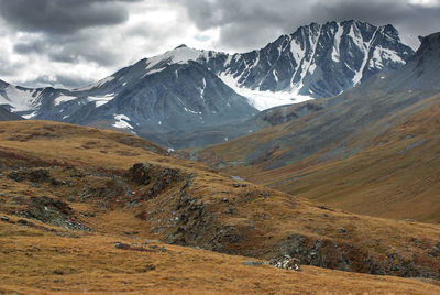 Scenic view of snowcapped mountains against cloudy sky