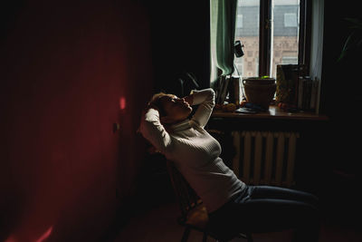 Young woman sitting on chair at home