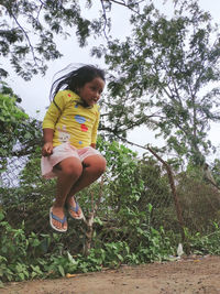 Low angle view of girl against trees