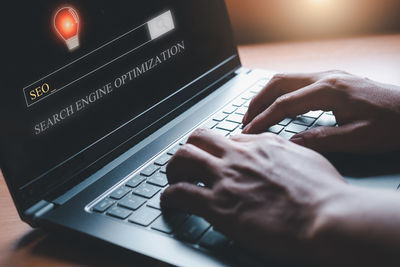 Midsection of man using laptop on table