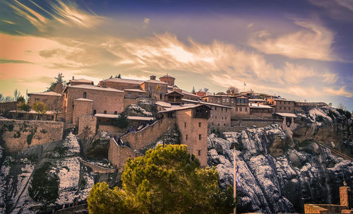 Low angle view of houses on snowcapped mountain against sky