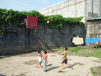 Children playing against built structure