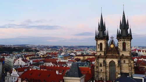 Tyn church amidst buildings against sky at dusk