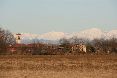 Houses on field against mountain range