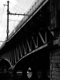 Low angle view of bridge over river against sky