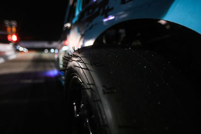 Close-up of wet car on road at night