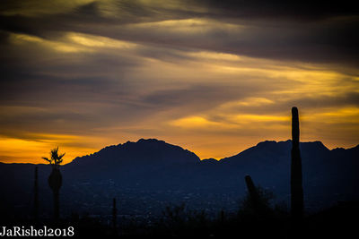 Scenic view of silhouette mountains against sky at sunset