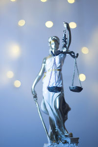 Close-up of lady justice against illuminated lights