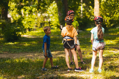 Full length of children on grass against trees