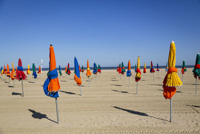 Multi colored umbrellas on beach against clear sky