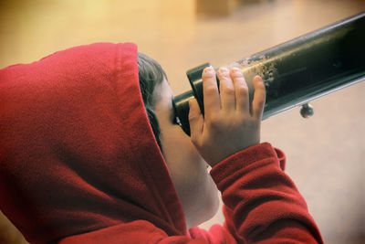 Young boy looking through telescope