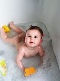 High angle view of cute baby bathing in bathtub at home
