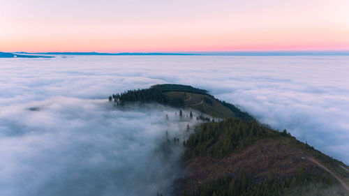 Scenic view of sea amidst cloudscape against orange sky