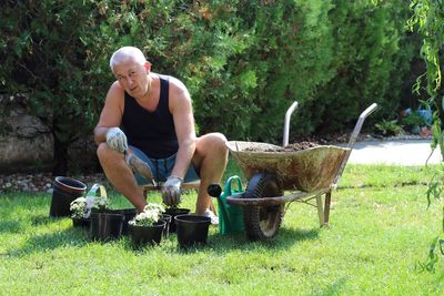 Full length portrait of man planting in garden