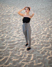 High angle view of young woman standing at beach