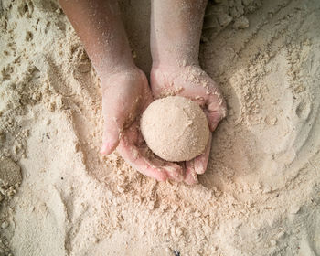 Hands making sphere sand ball by a child at the beach. play sand.