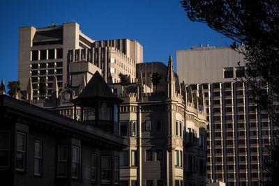 Low angle view of buildings against clear blue sky