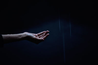 Close-up of human hand against black background