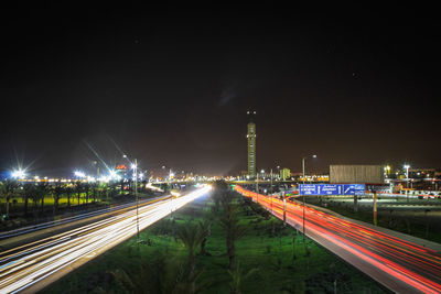 Light trails on road against sky at night