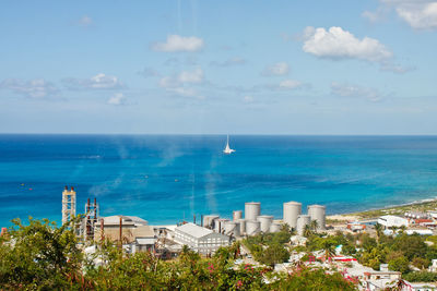 Scenic view of sea by buildings against sky