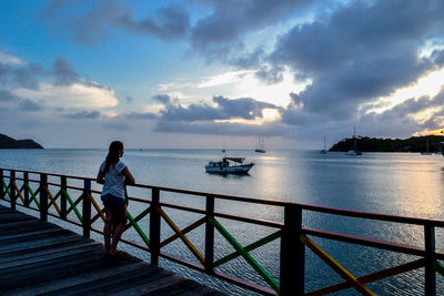 Full length of woman on pier looking at sea