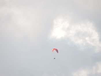 Low angle view of person paragliding against sky