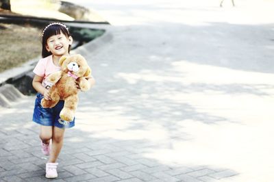 Full length of happy girl holding toy