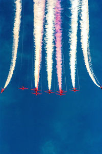 Low angle view of airplane flying against blue sky