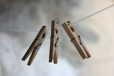 Low angle view of clothespins hanging on rope