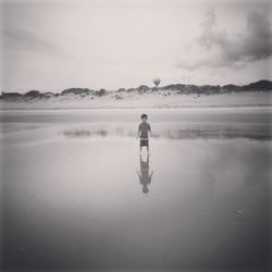 Rear view of woman standing on beach