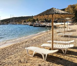 Chairs on beach against clear sky