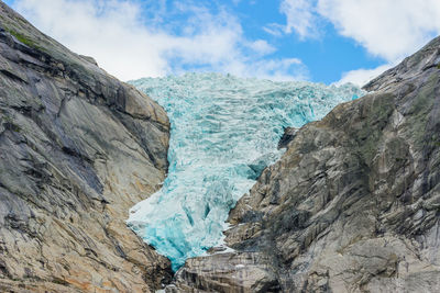 Low angle view of glacier against sky