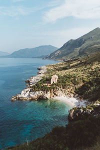 Scenic view of sea by buildings against sky