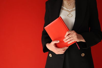 Midsection of woman holding gift against yellow background