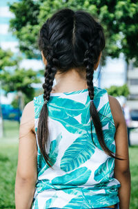 Rear view of girl with pigtails standing at park