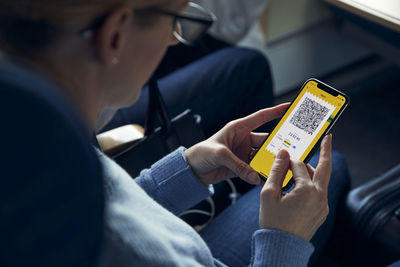 Woman holding cell phone with e-ticket