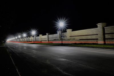 Light trails on road against sky at night