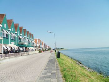 Road by sea against clear sky