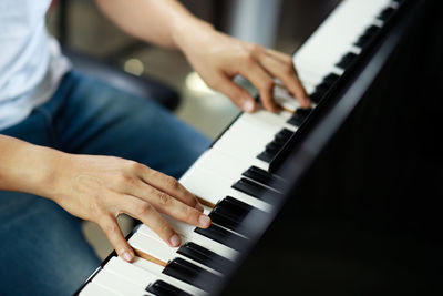 Midsection of man playing piano