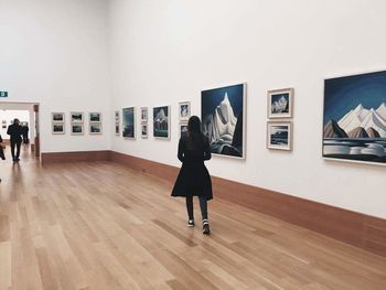 Full length rear view of woman standing in museum