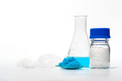 Close-up of glass jar on table against white background