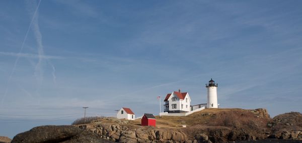 Lighthouse on hill against sky