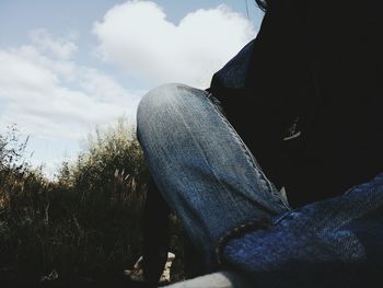 Low section of woman sitting outdoors