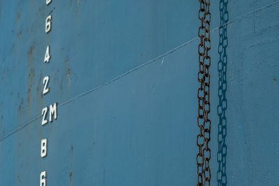 Close-up of chain hanging against wall