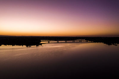 Scenic view of lake against clear sky during sunset